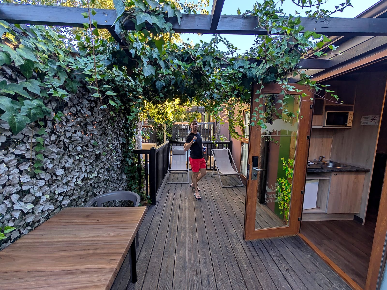 El patio de madera con pérgola de hiedra de la cabaña para cuatro personas del Magic Robin Hood