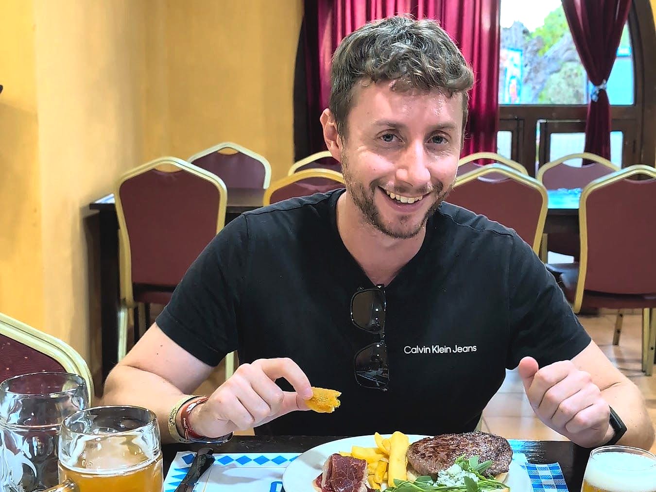Javier Sobrino cenando una hamburguesa con cerveza en el buffet del Magic Robin Hood