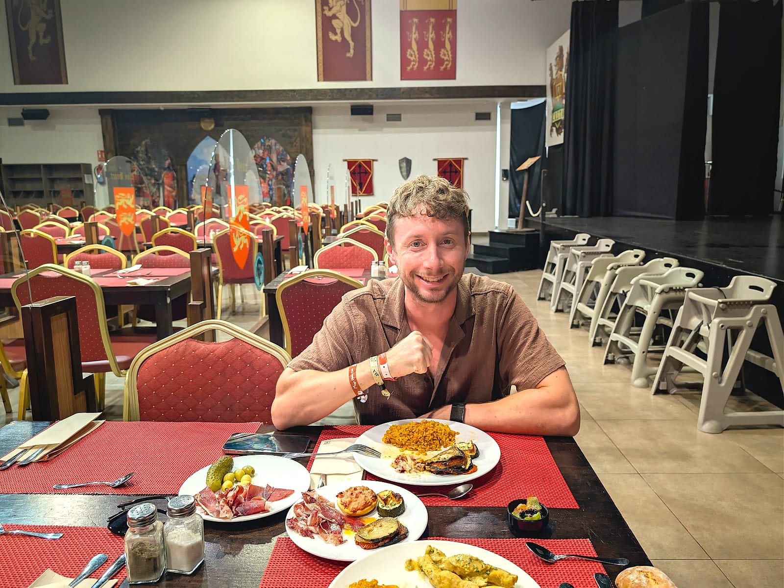 Javier Sobrino sonriendo a la mesa del comedor medieval del Magic Robin Hood, con arroz, jamón y verduras