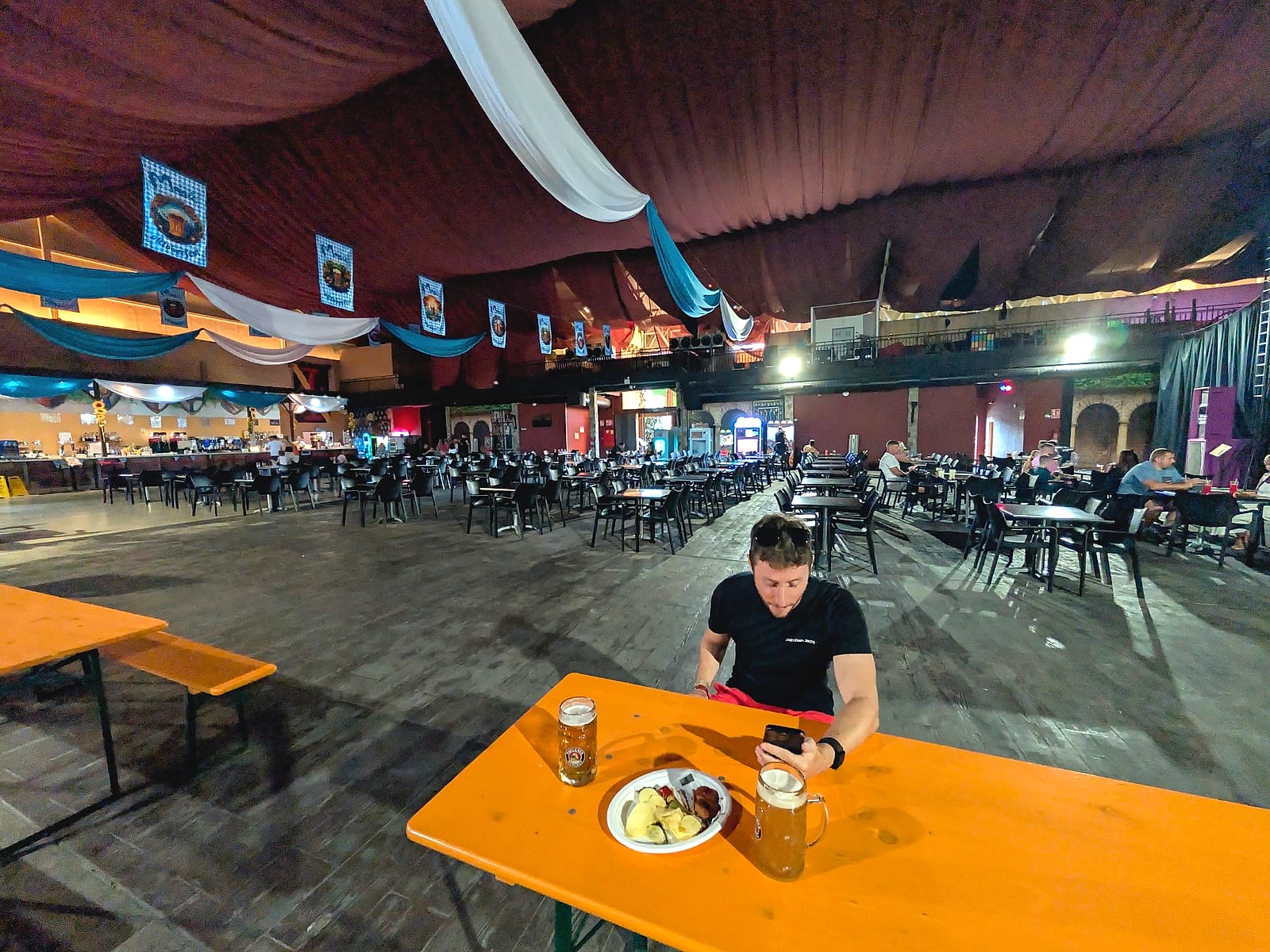La gran sala del Oktoberfest del Magic Robin Hood, con techo de carpa y banderines bávaros