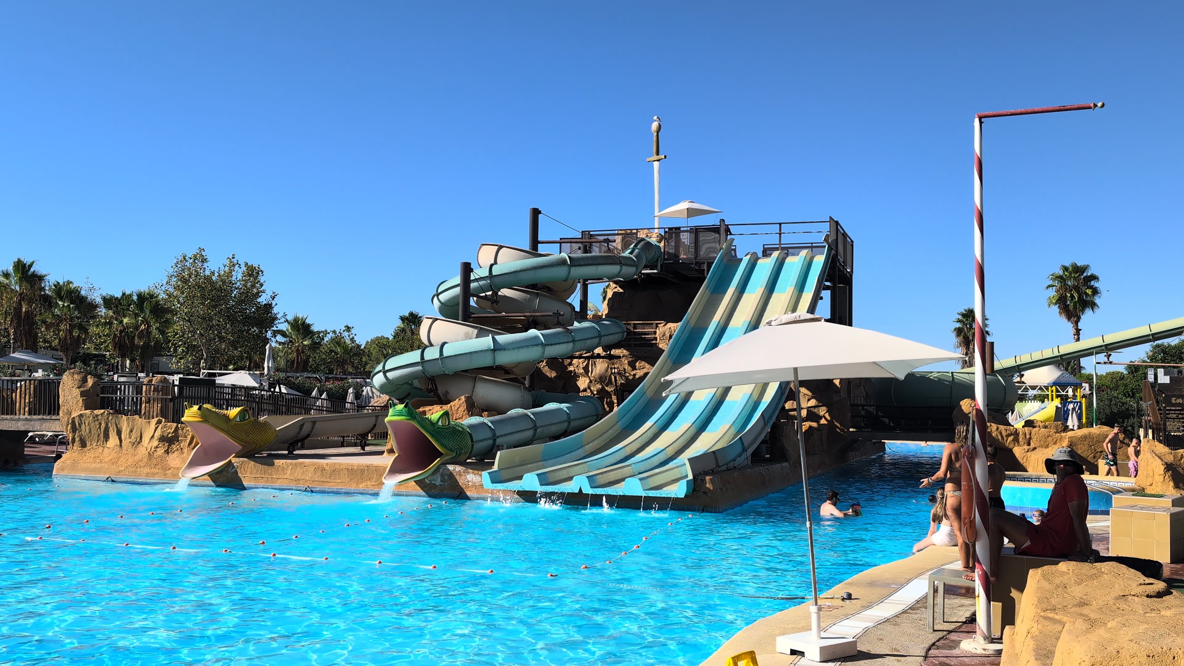 Toboganes con bocas de rana y espada gigante sobre la piscina del Magic Robin Hood Resort