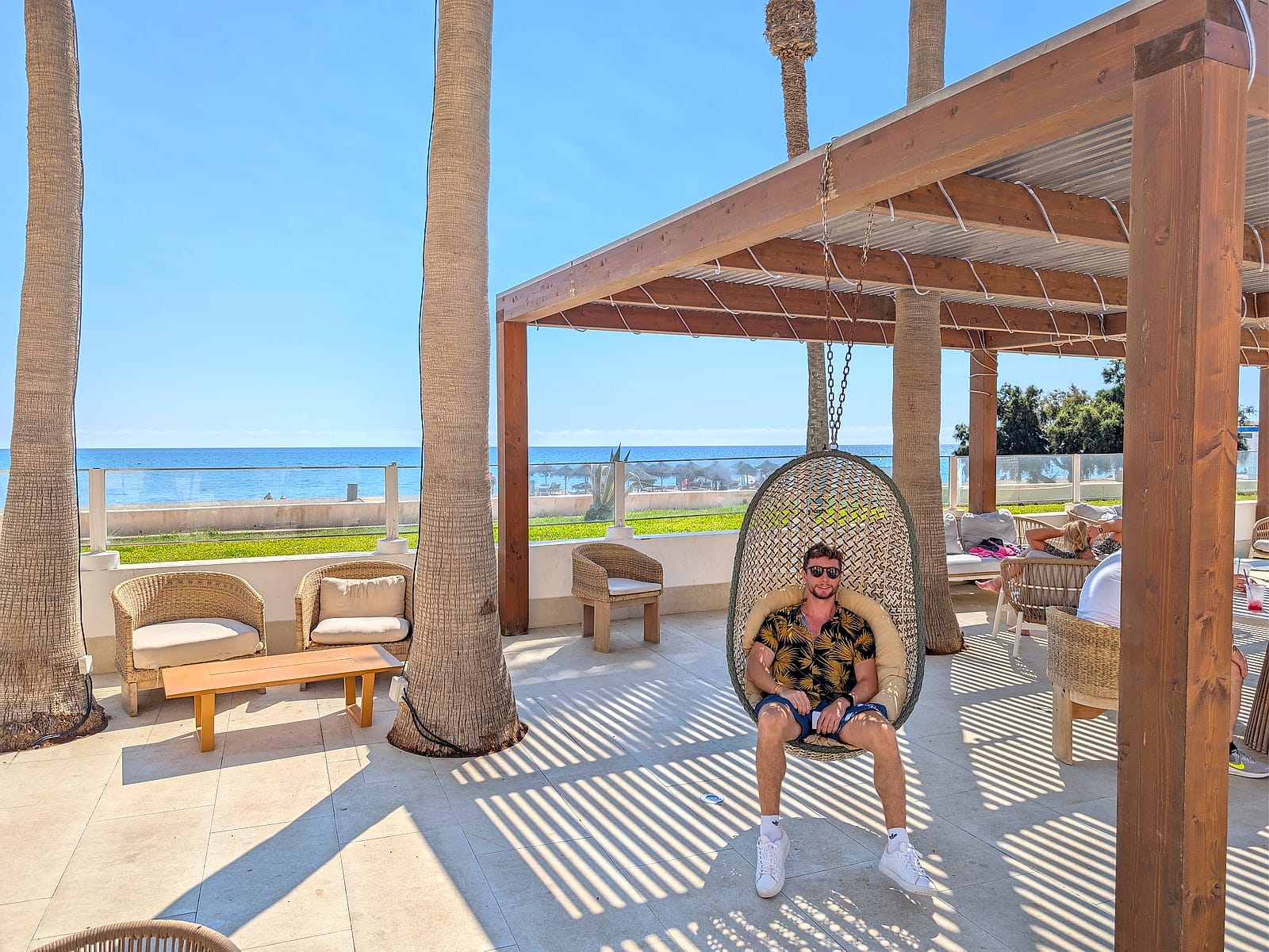 Javier Sobrino en un sillón colgante de la zona chill out del Mediterráneo Bay, con el mar detrás