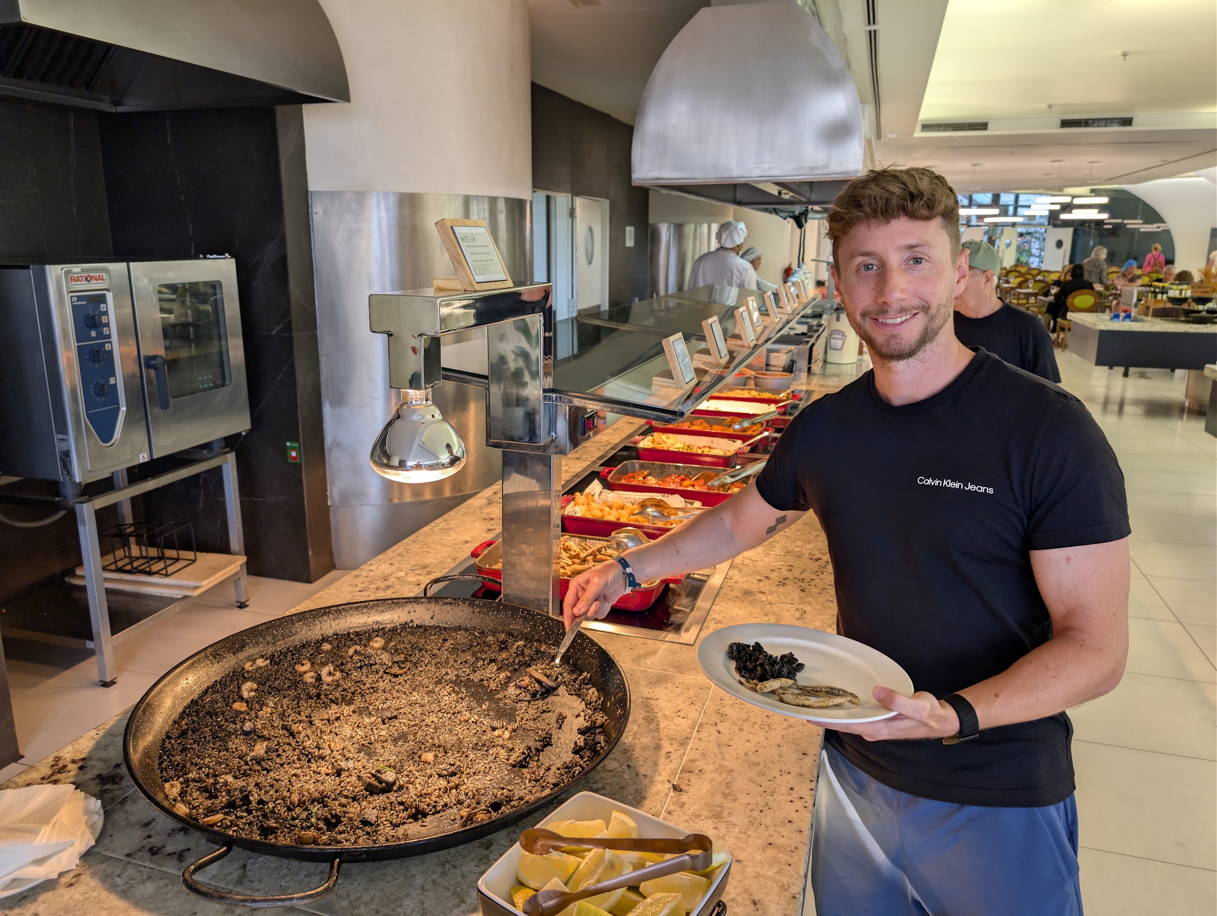 Javier Sobrino sirviéndose arroz negro de una paella en el buffet del Meliá Benidorm