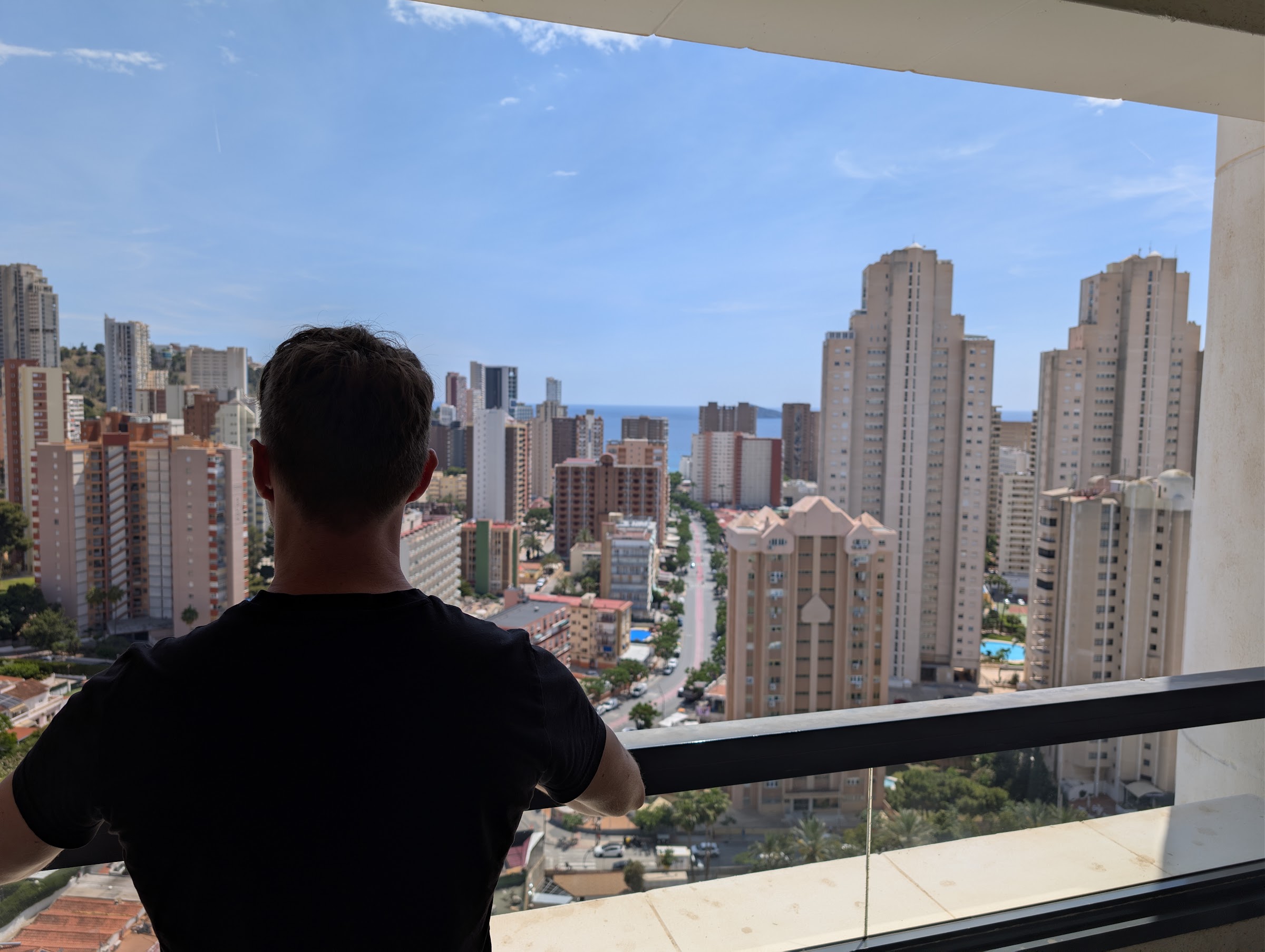 Javier Sobrino de espaldas en la terraza del Meliá Benidorm mirando los rascacielos y el mar