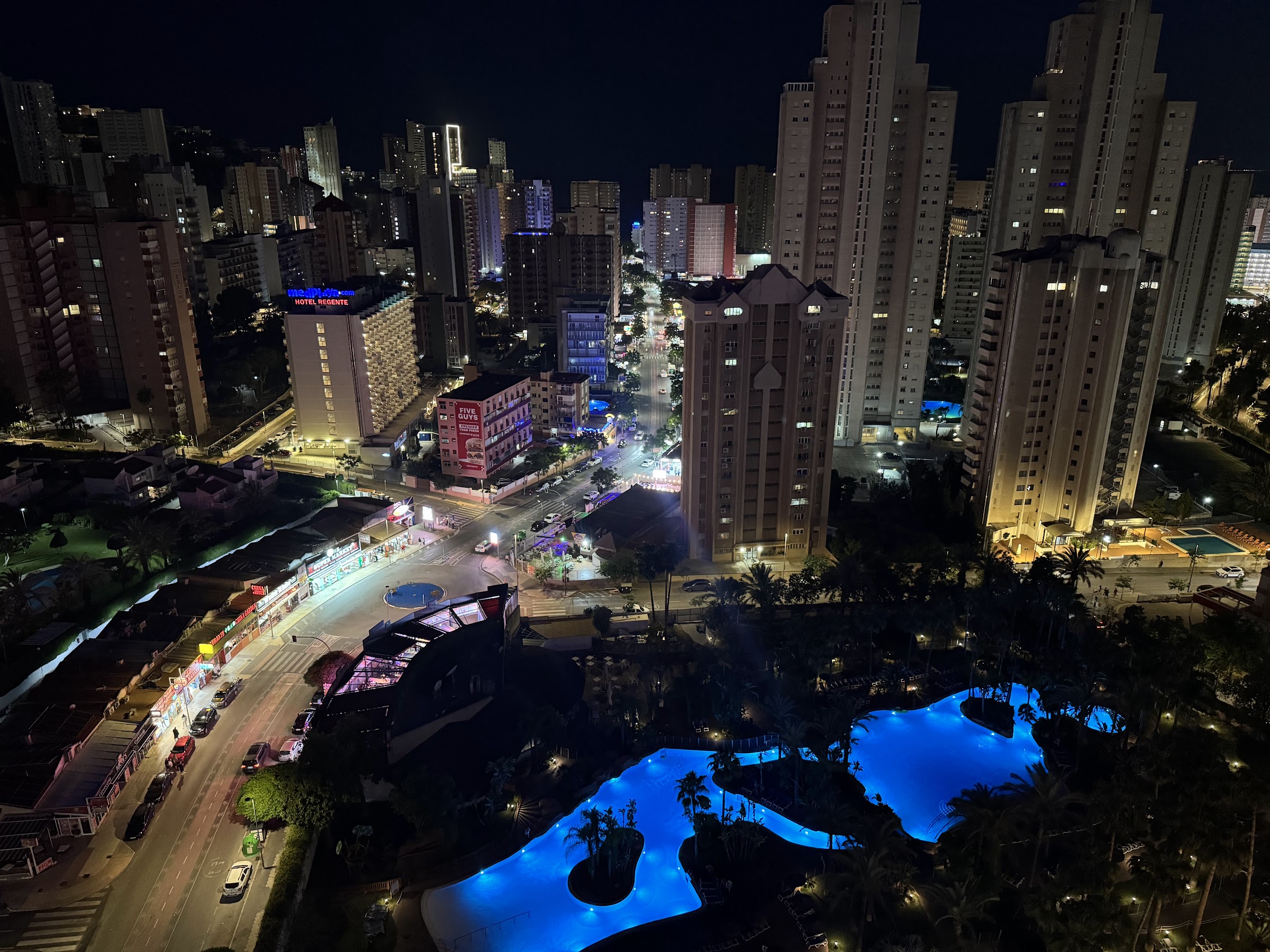 Piscinas iluminadas del Meliá Benidorm y el skyline de Benidorm de noche