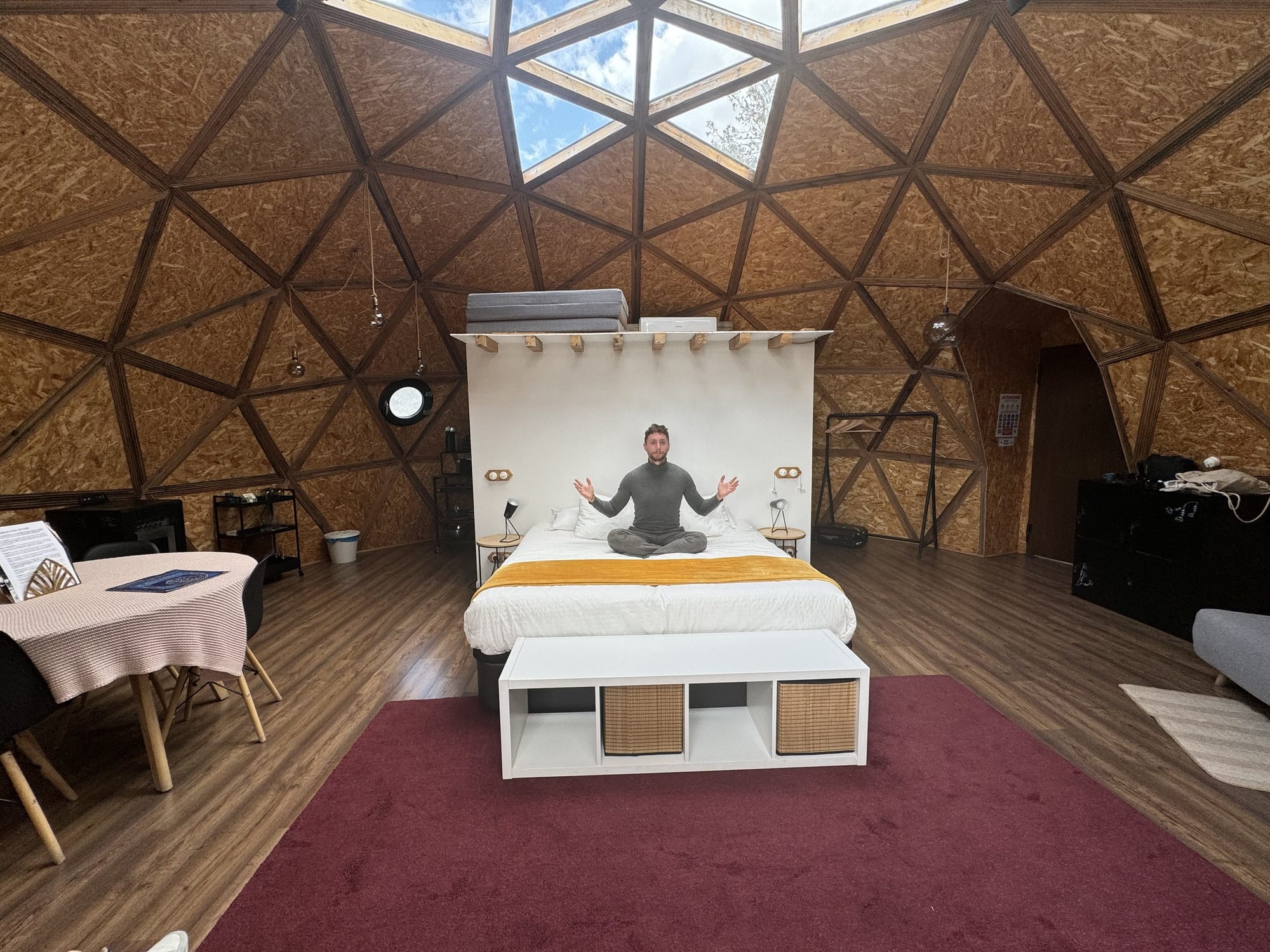 Javier Sobrino sentado en la cama del domo de Miradomos bajo las claraboyas