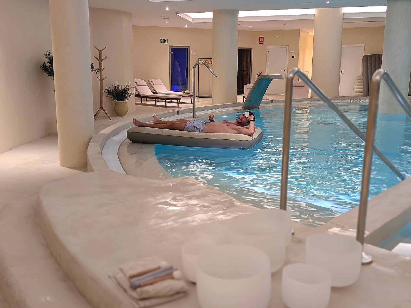 Cuencos de cuarzo junto a la piscina interior del Pontiana Thalasso y Javier Sobrino flotando en una colchoneta