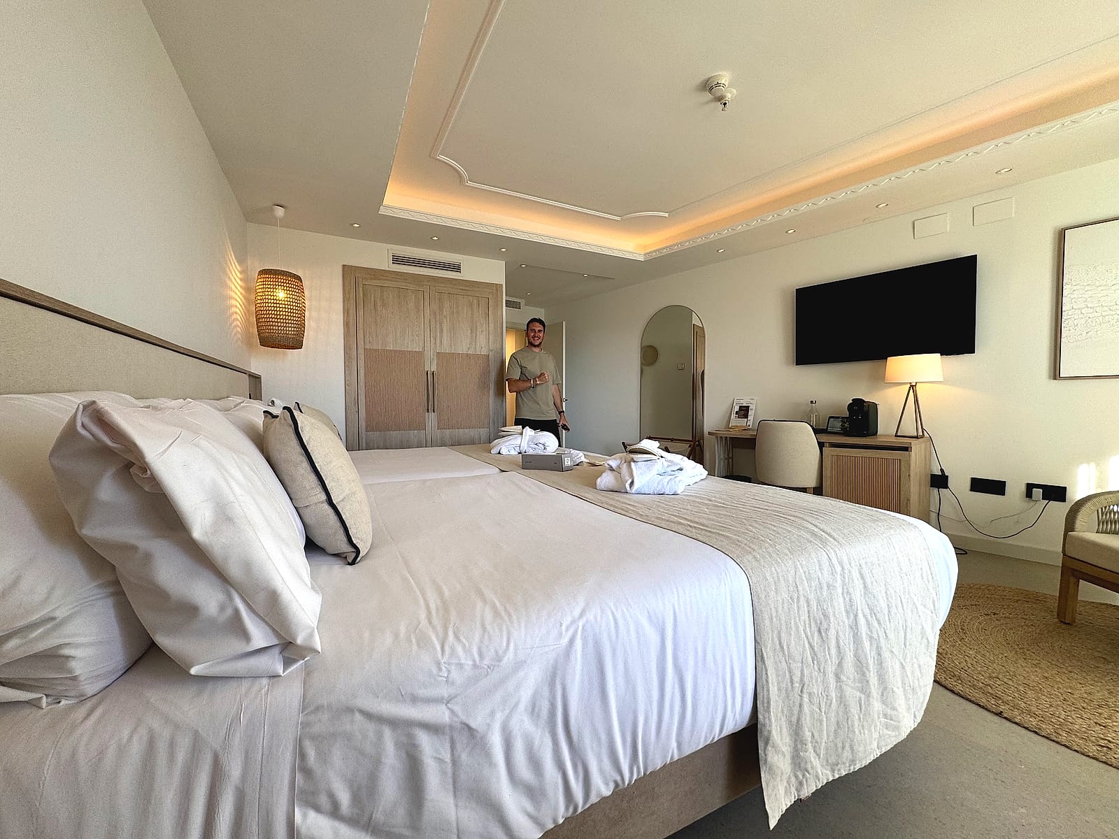 La habitación doble del Pontiana Thalasso, en tonos crema, con dos camas y la televisión