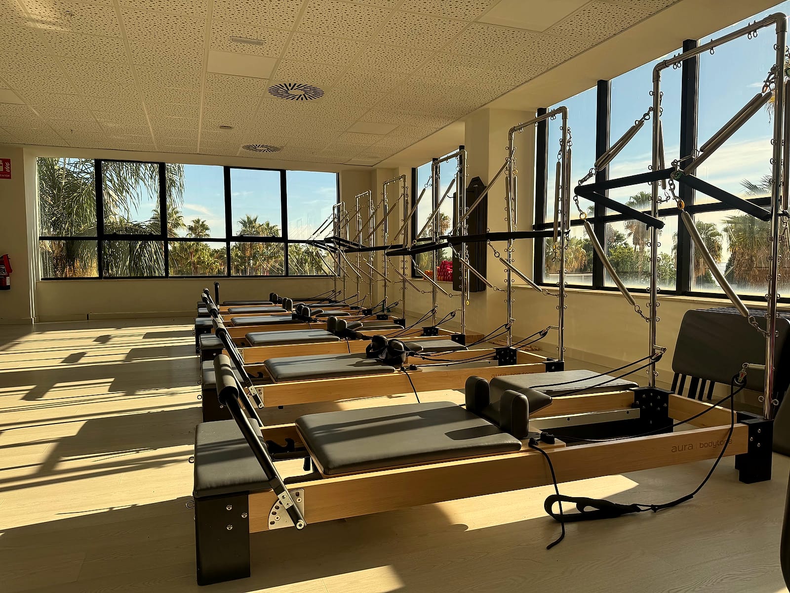 La sala de pilates de máquina del gimnasio del Pontiana Thalasso, con los reformers junto a los ventanales