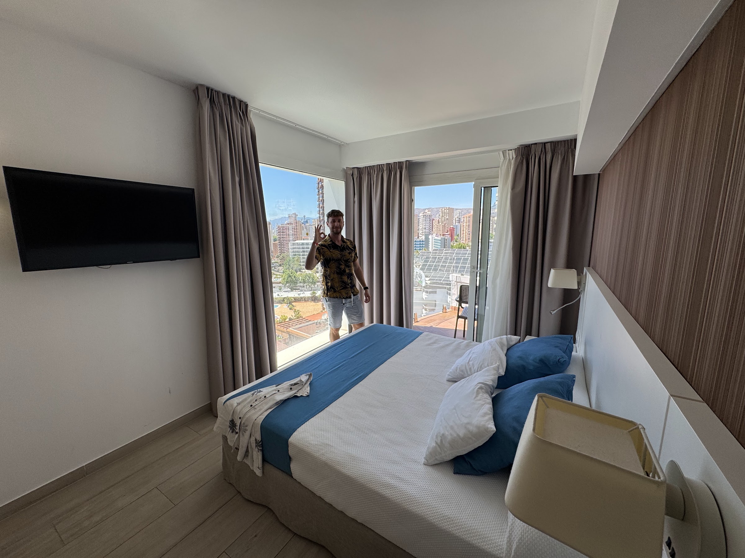 Dormitorio del Hotel Rosamar Benidorm con cama king size y ventanales a la ciudad
