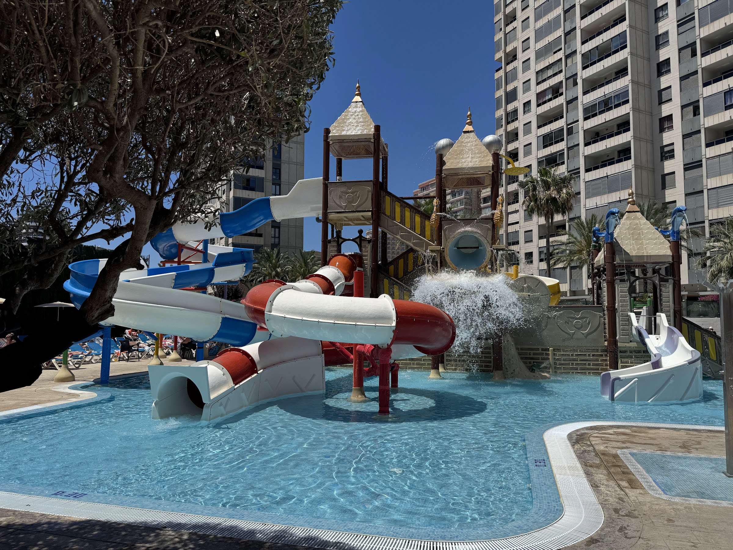 Cubo de agua del mini parque acuático del Hotel Rosamar Benidorm volcando sobre los toboganes