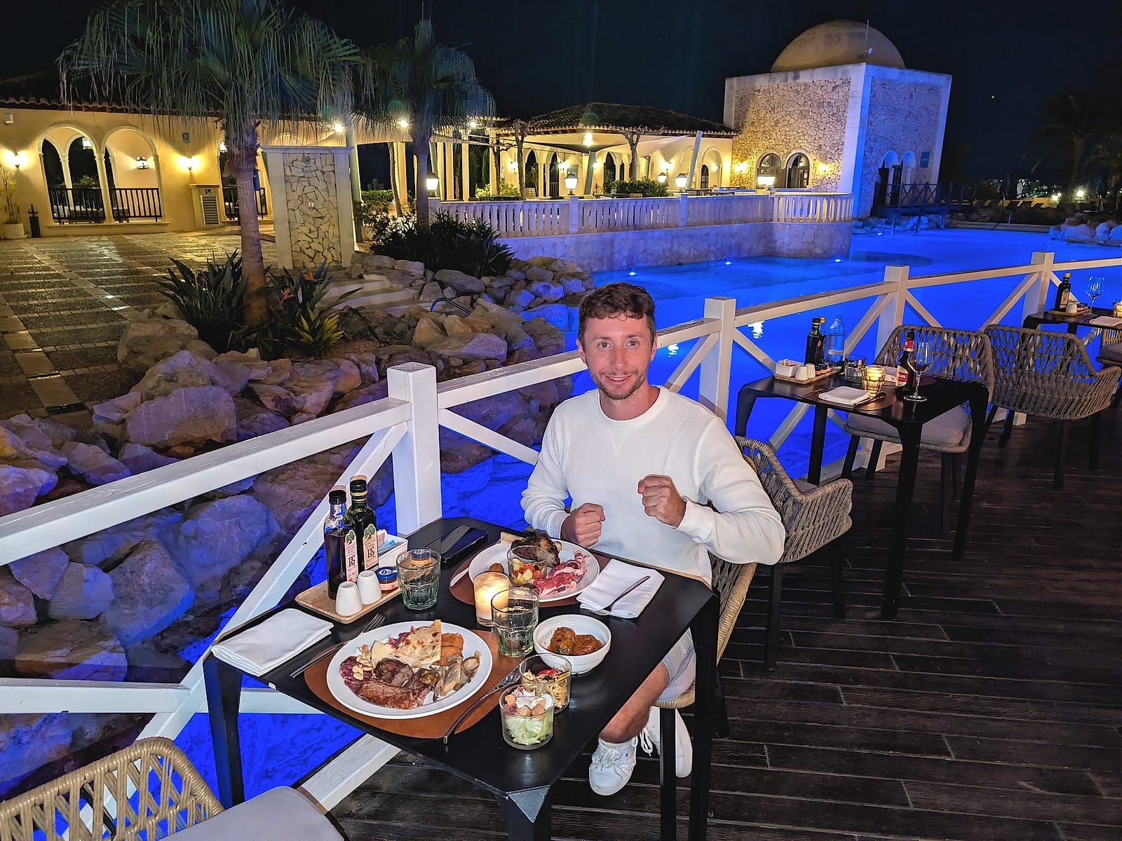 Javier Sobrino cenando en la terraza de The Level, con la piscina iluminada detrás