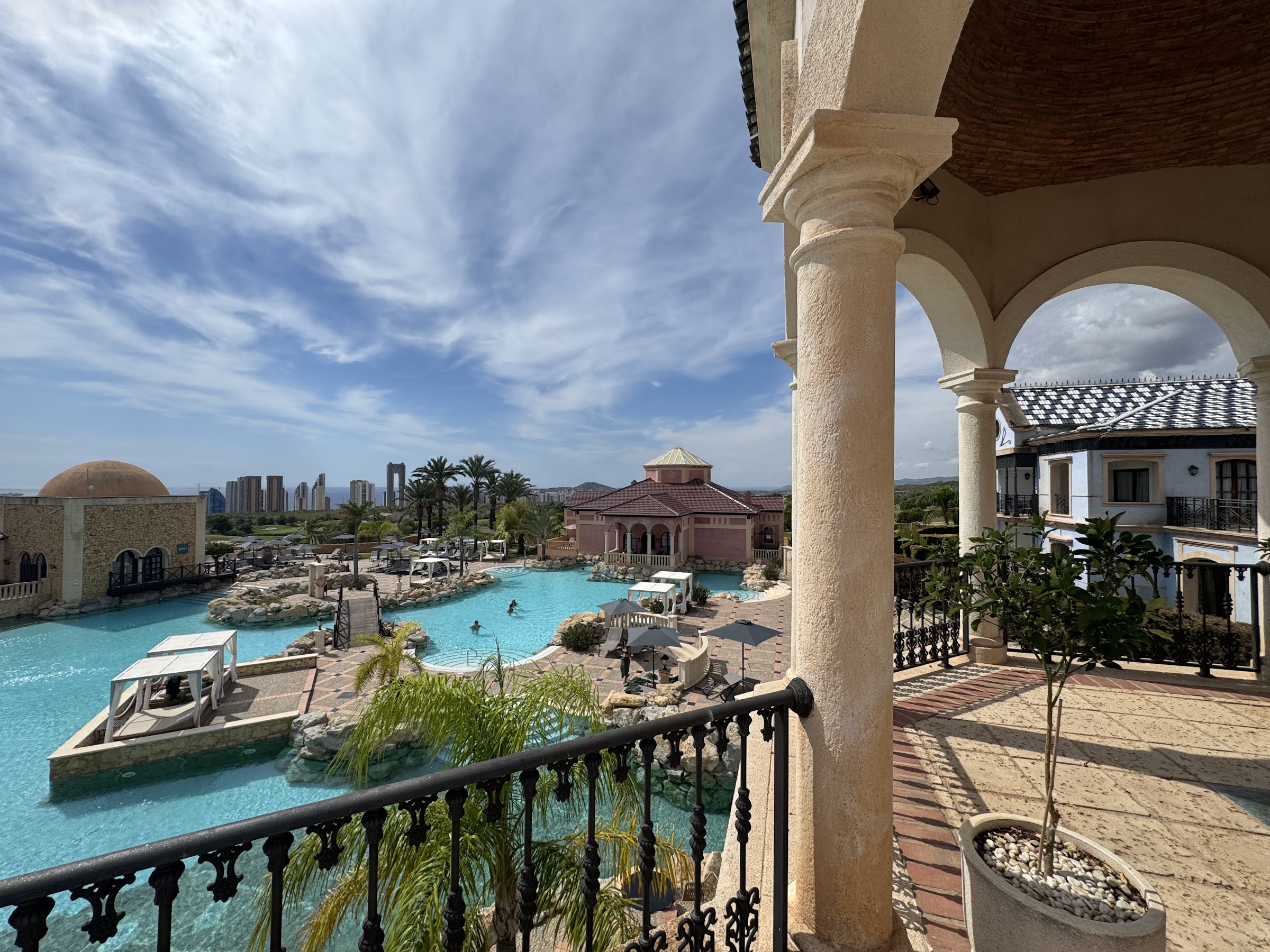Piscina estilo lago vista desde una terraza con columnas del Meliá Villaitana