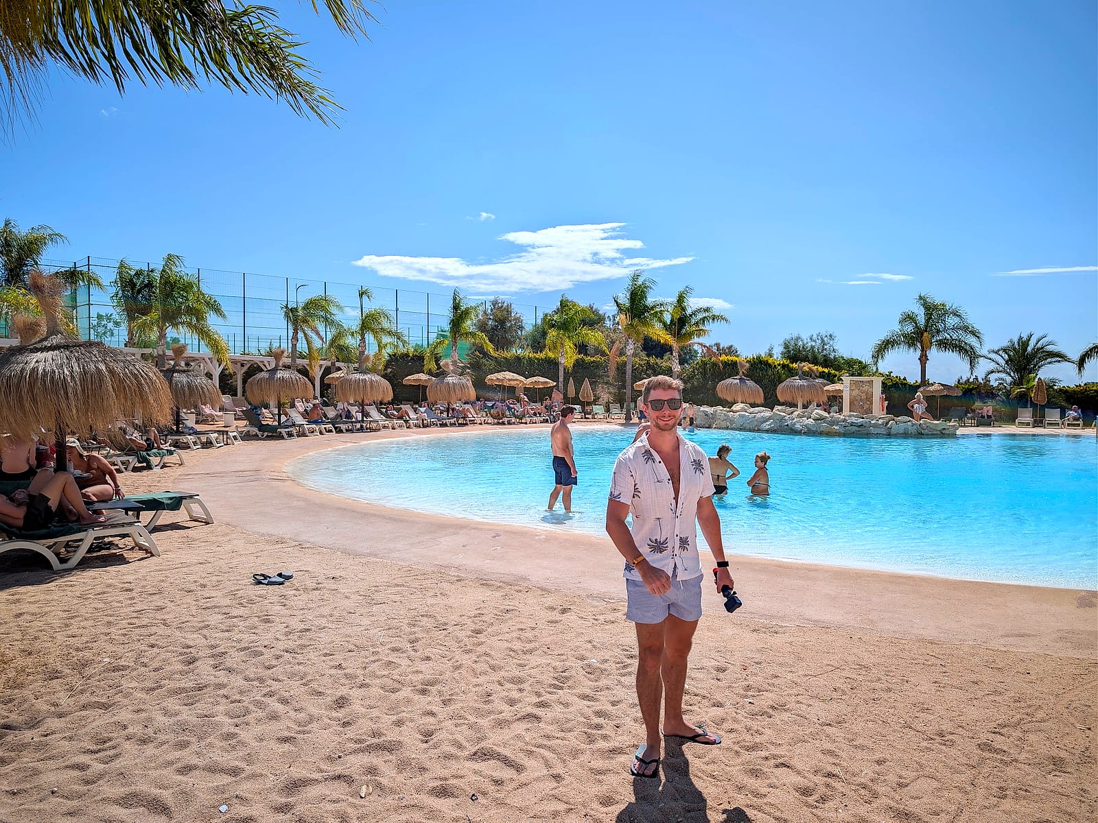 Javier Sobrino en la piscina tipo playa del Meliá Villaitana, con arena y sombrillas de paja