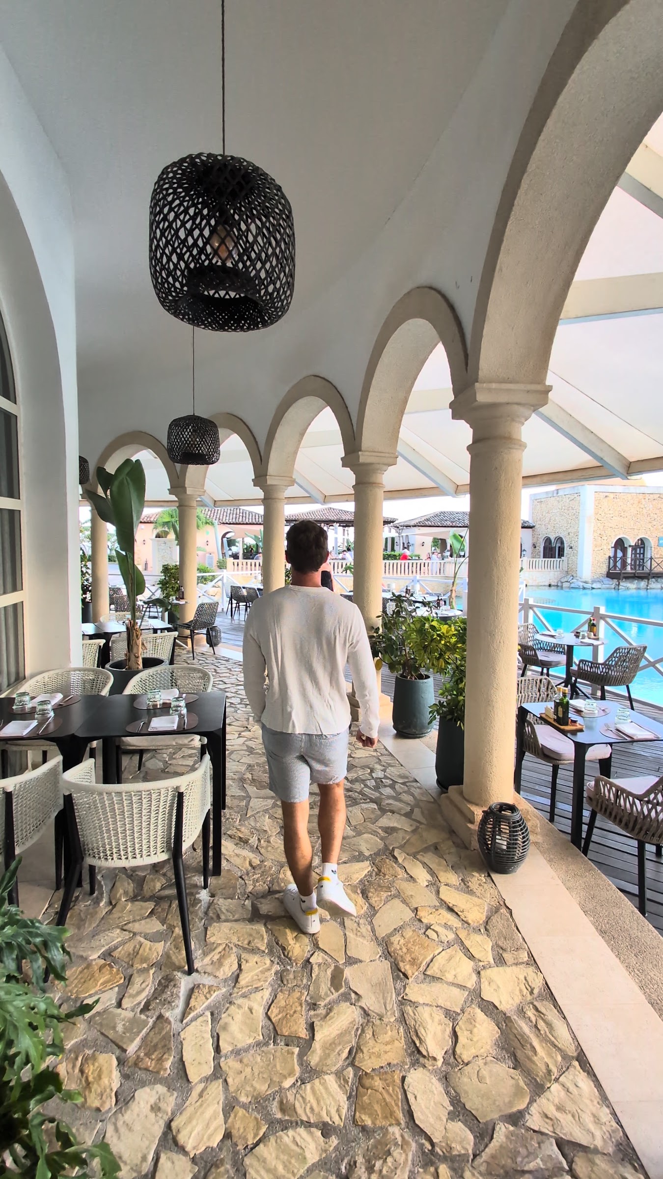 Javier Sobrino paseando por la terraza porticada del restaurante junto a la piscina del Meliá Villaitana