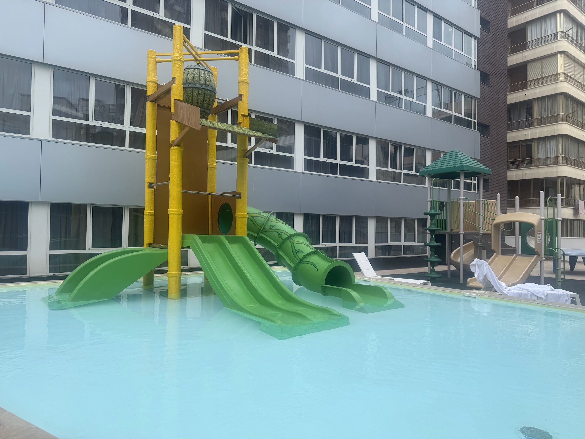 Mini aquapark con toboganes verdes en la piscina infantil del Hotel Villa del Mar